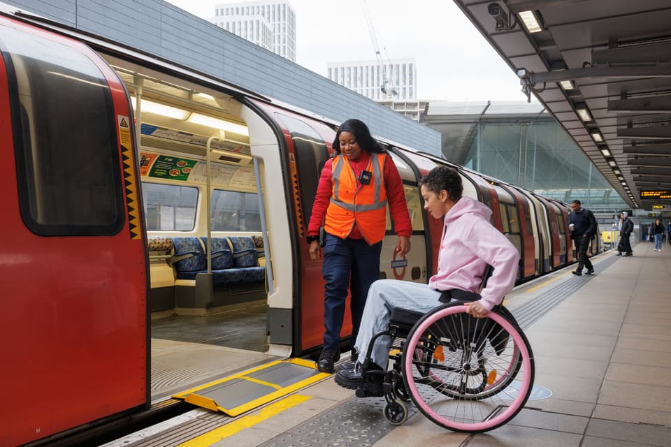 A TfL staff member helps a customer use a new mini ramp
