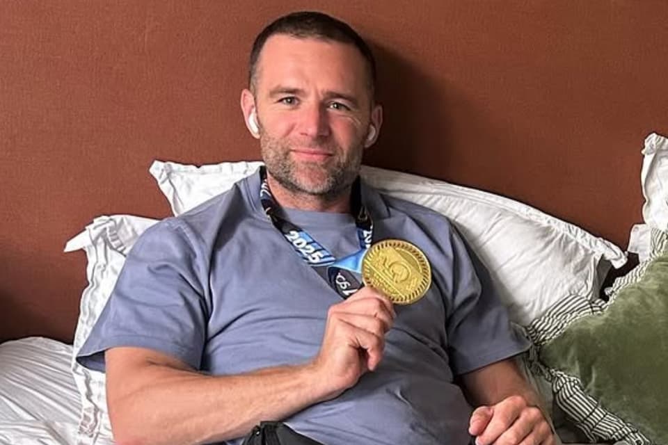 Harry Judd holding his marathon medal