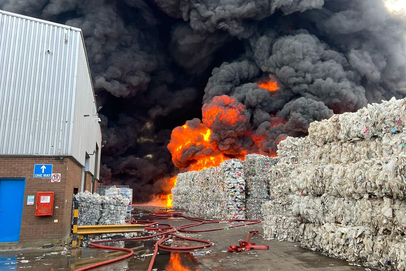 Black smoke seen as firefighters tackle large fire at recycling warehouse
