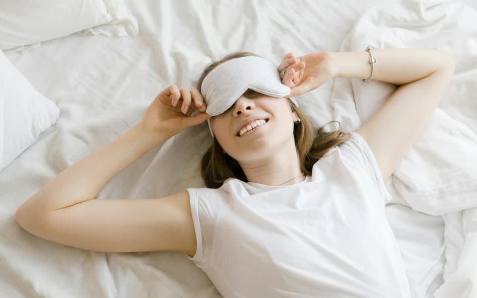 Woman smiling with a sleeping mask on
