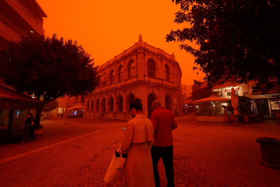 People walk amid a haze caused by sand dust from the Sahara, due to strong southern winds, in Heraklion, Crete island, April 1, 2026. REUTERS/Stefanos Rapanis     TPX IMAGES OF THE DAY