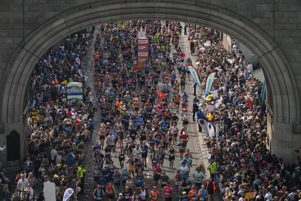 Runners are seen from inside Tower Bridge as they cross the River Thames