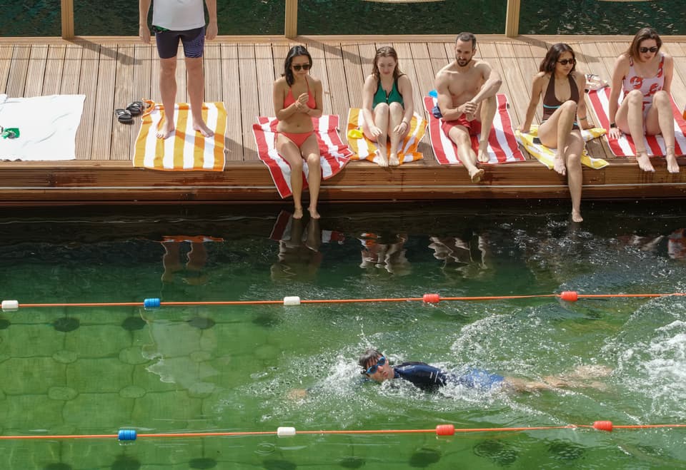 Swimmers during the opening of Sea Lanes Canary Wharf, in London, the new 50m fresh-water pool floating on top of the Thames 