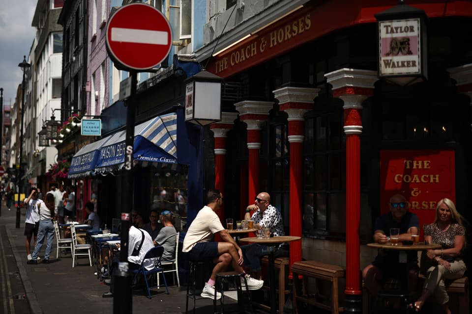 Members of the public enjoy a drink in the sunshine outside a pub in the Soho area of London on June 18, 2023. Recent data showed UK inflation slowed to a 13-month low in April, but remains elevated at 8.7 percent as soaring food prices offset weaker energy costs. (Photo by HENRY NICHOLLS / AFP) (Photo by HENRY NICHOLLS/AFP via Getty Images)