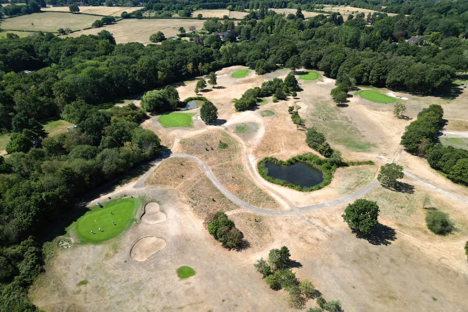 <p>TOPSHOT - An aerial view shows the parched, dry and yellow grass on the fairways of Sutton Green Golf Club, south-west of London on July 25, 2026, during the extended heatwave. Several areas of southern England were at "exceptional" risk of major wildfires, according to government advisory body Natural England, as Britain has faced unprecedented heatwaves for much of the last two months. (Photo by Justin TALLIS / AFP via Getty Images)</p>