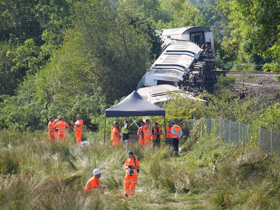 <p>Rail staff at the scene where a train derailed near Lewes</p>