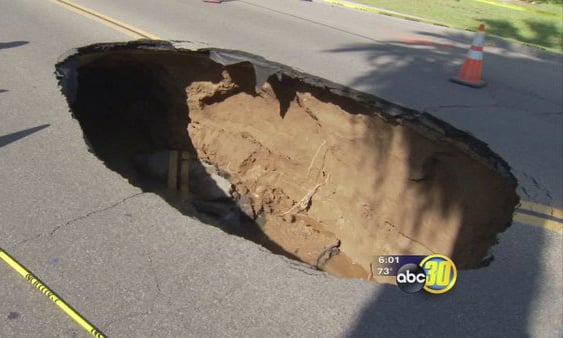 Moment a 20ft-deep sinkhole appears in middle of a road in US | London Evening Standard
