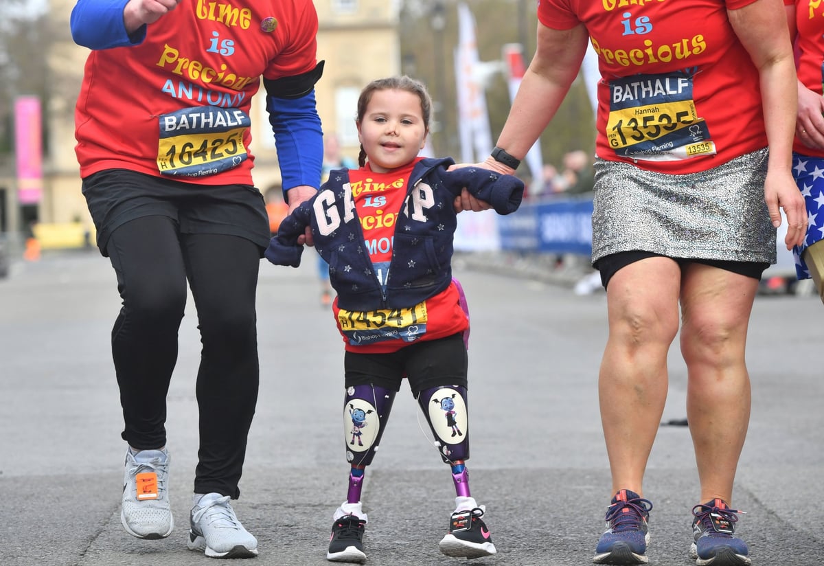 Moment five-year-old girl who lost all her limbs to meningitis crosses finish line of half marathon in Bath | London Evening Standard
