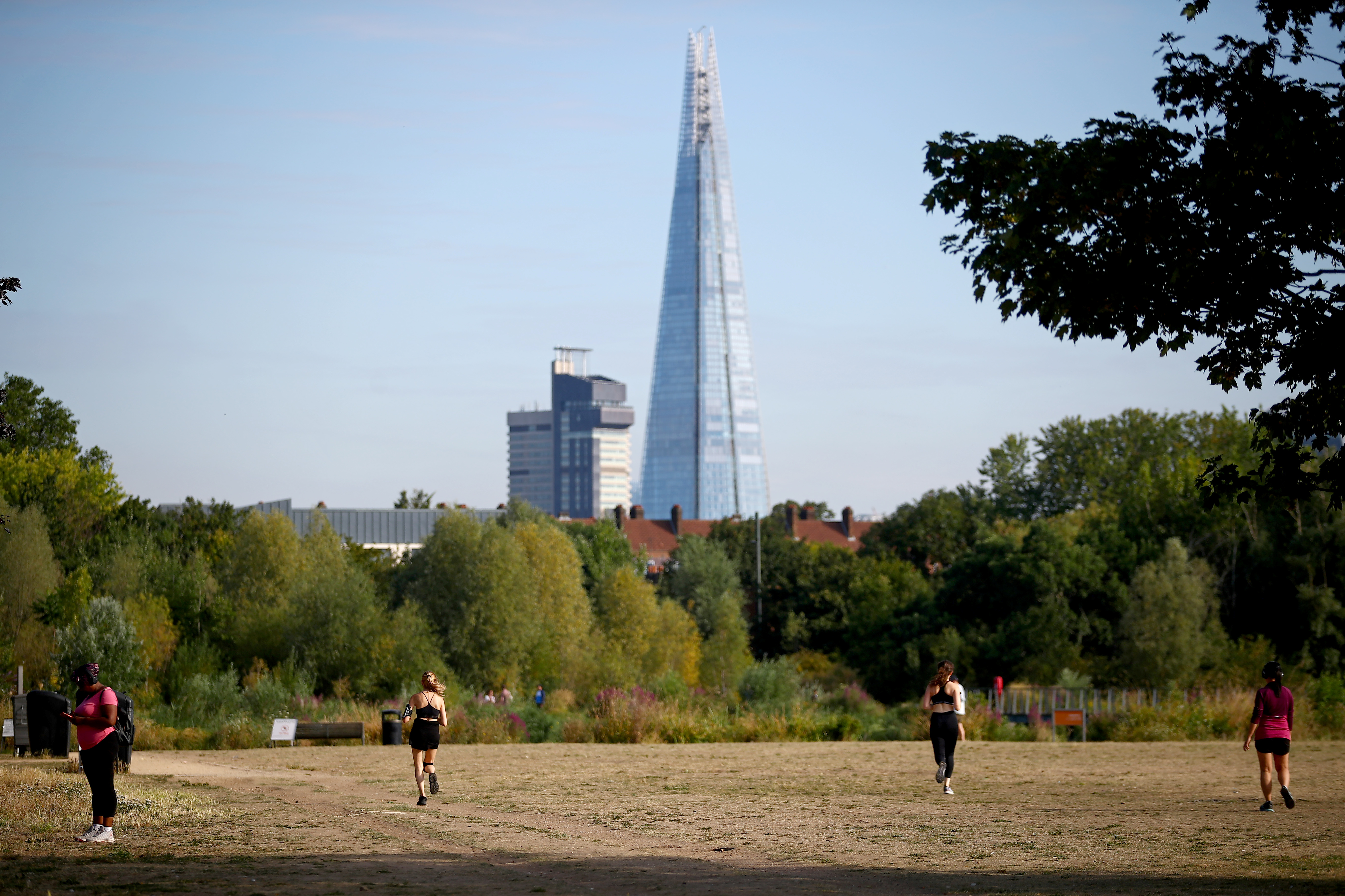 People jog through Burgess Park in London