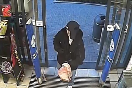 Moment thug threatens convenience store staff with fake gun