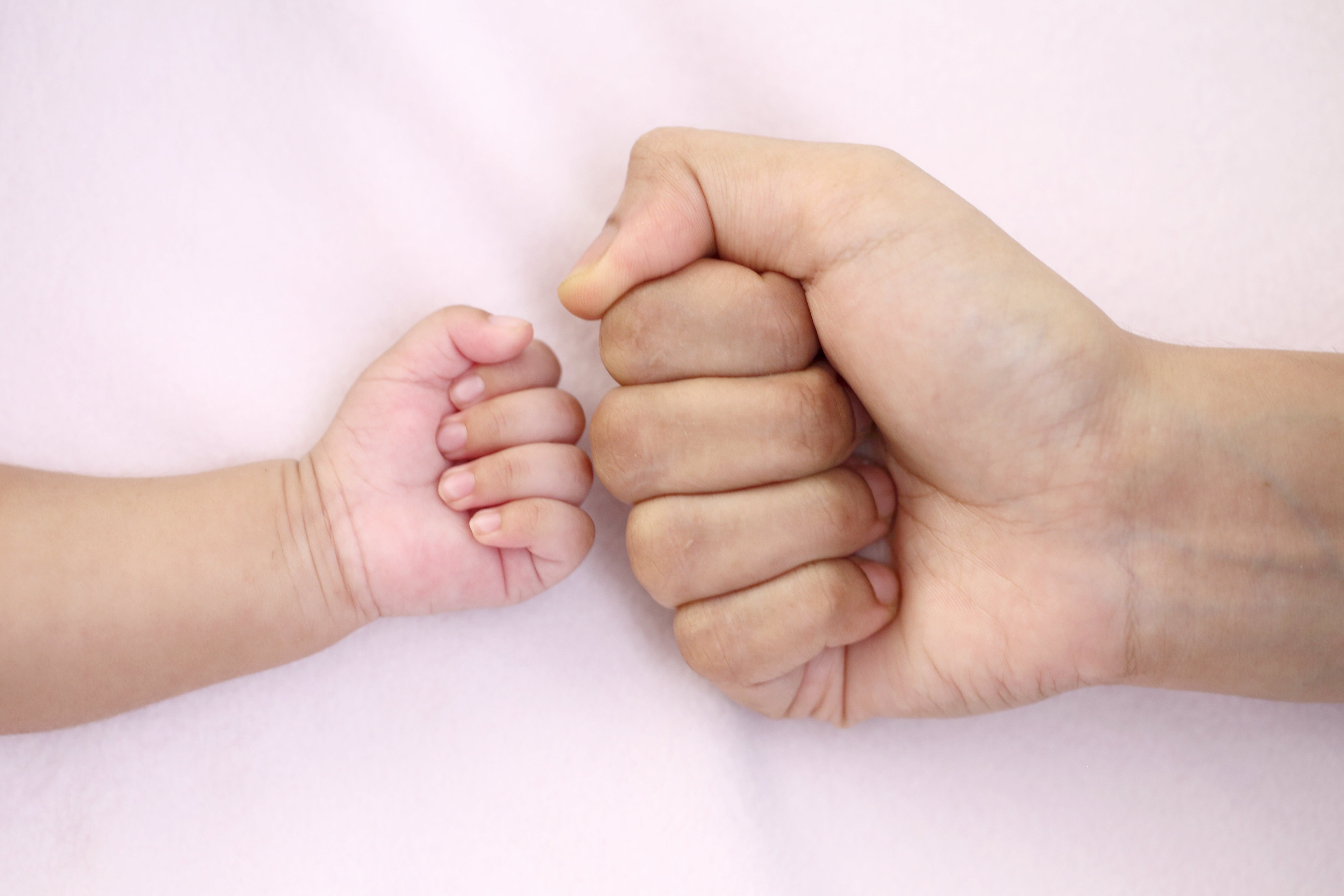 Fist of mother and baby close up
