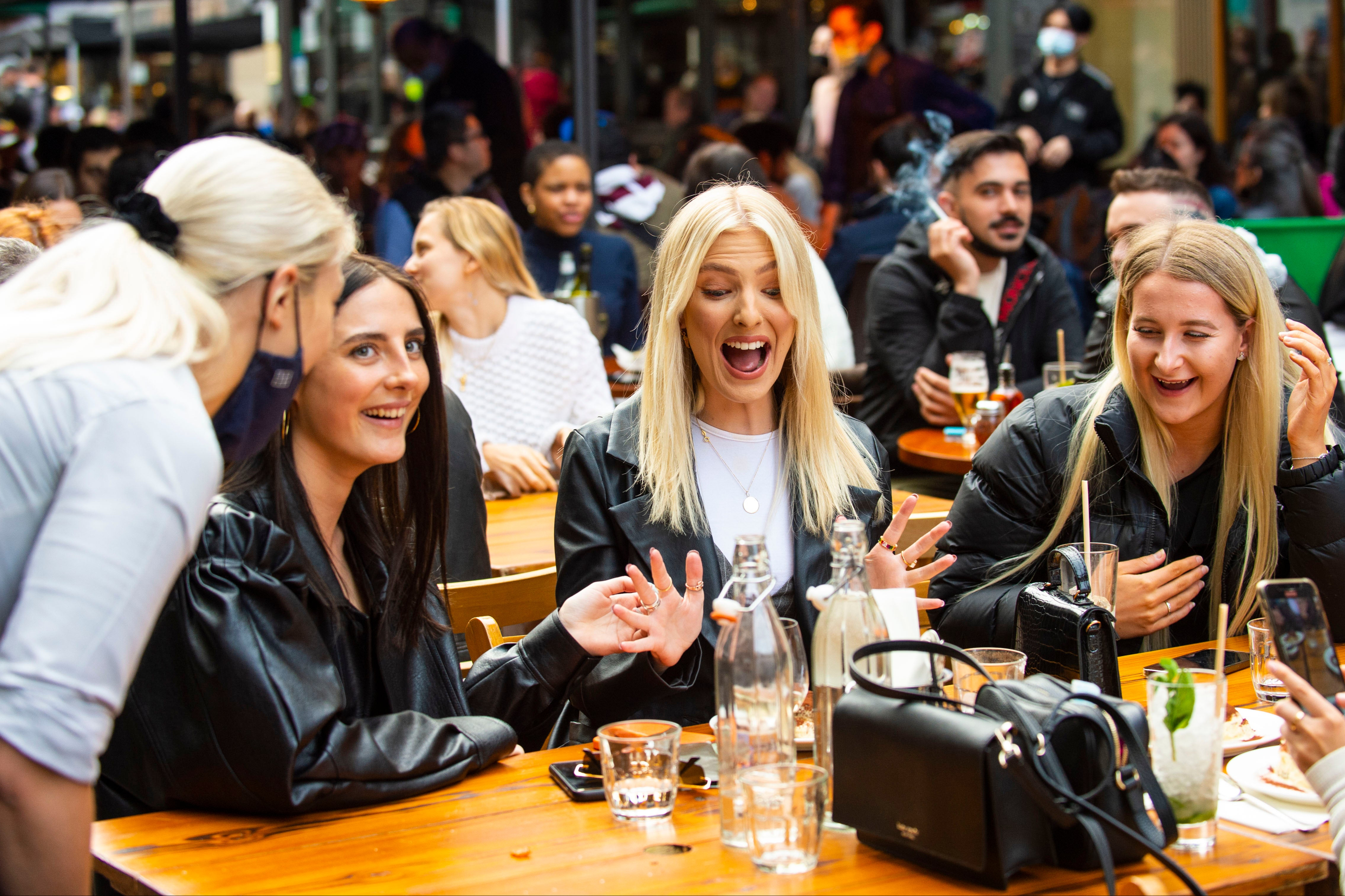 Members of the public enjoy sunshine and drinks in Soho.