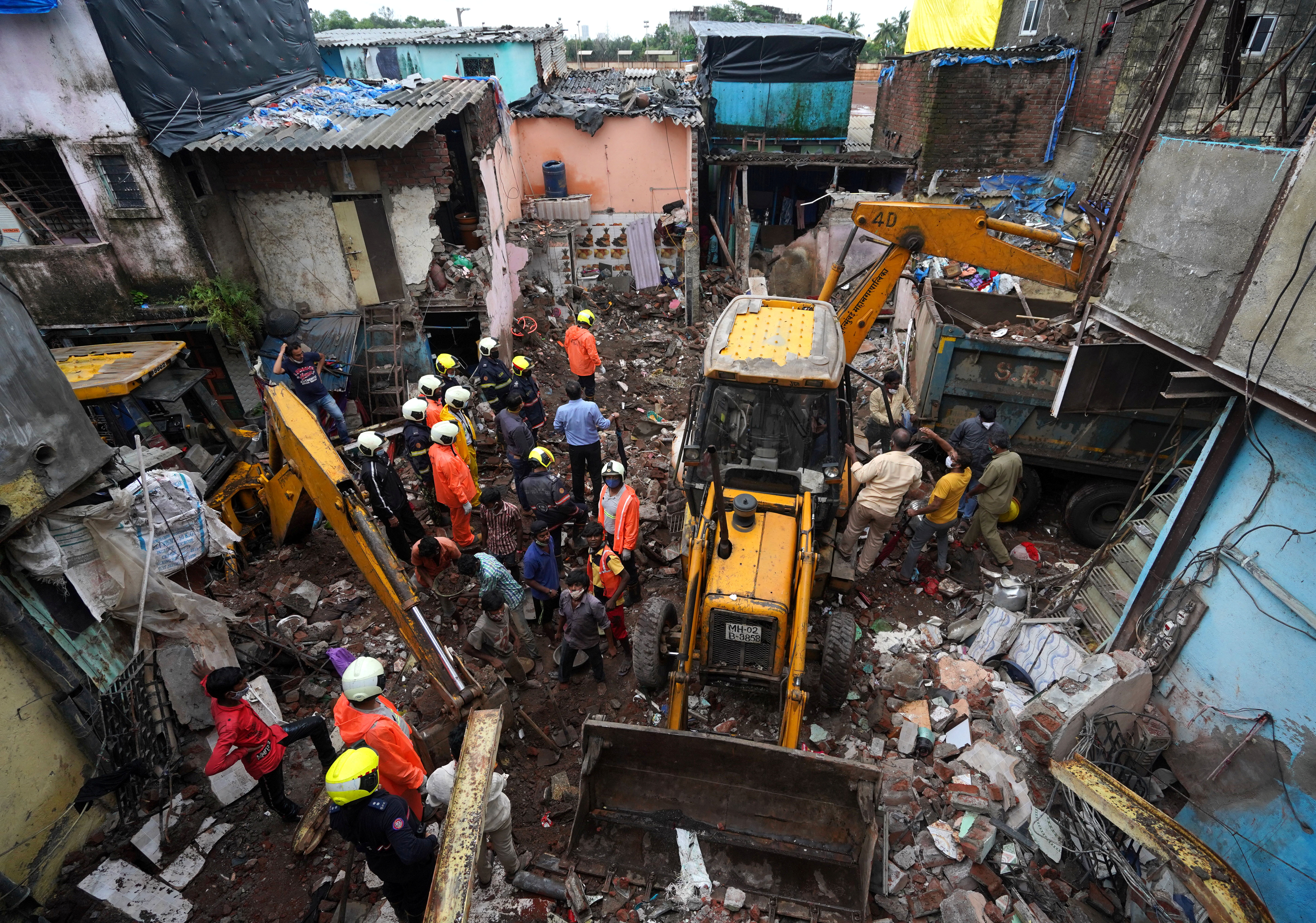 Rescue workers remove debris to search for survivors after a residential building collapsed on top of another building in Mumbai