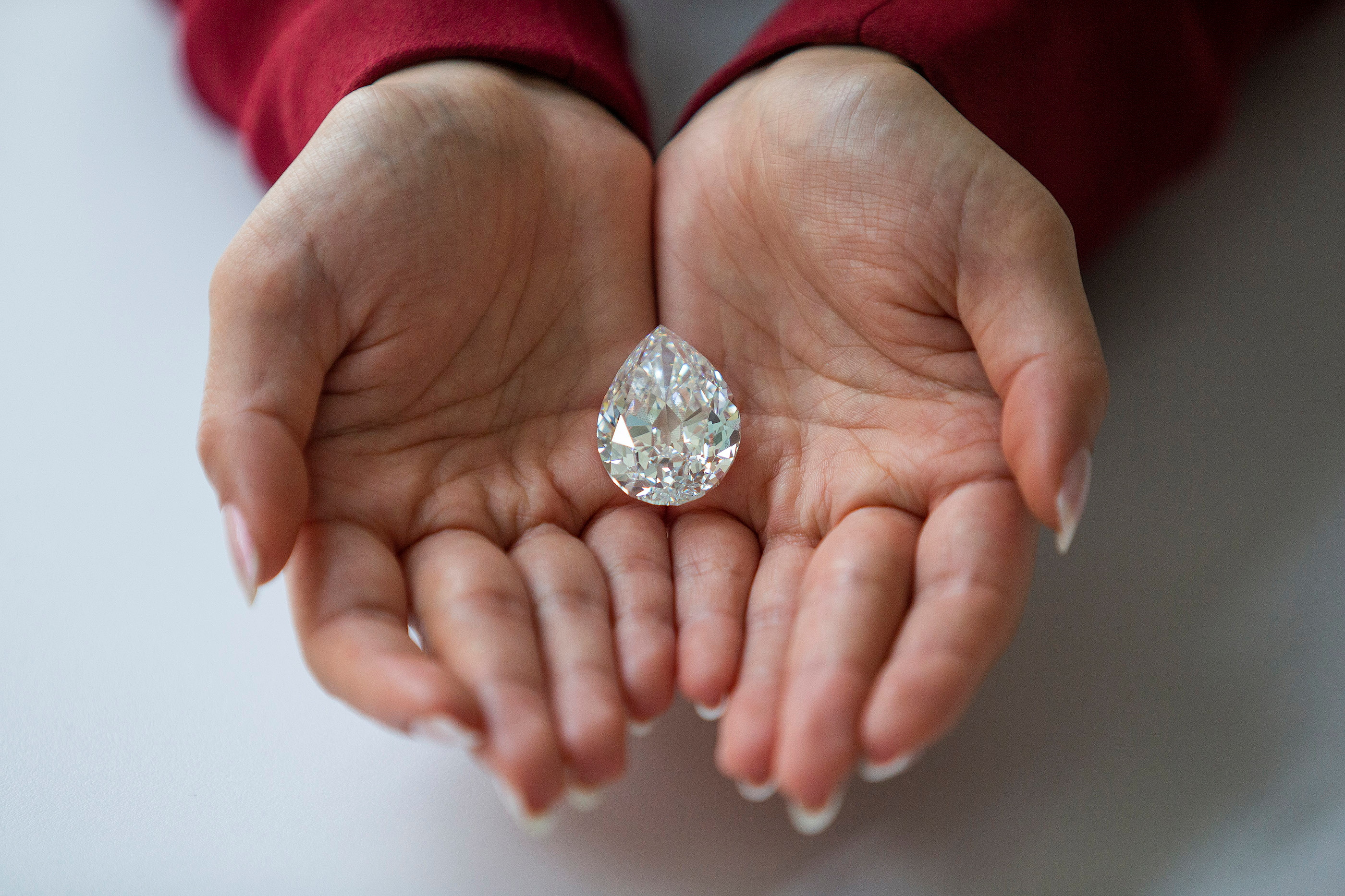 An employee of Sotheby's poses with a rare flawless 100+ carat diamond at Sotheby's in New York