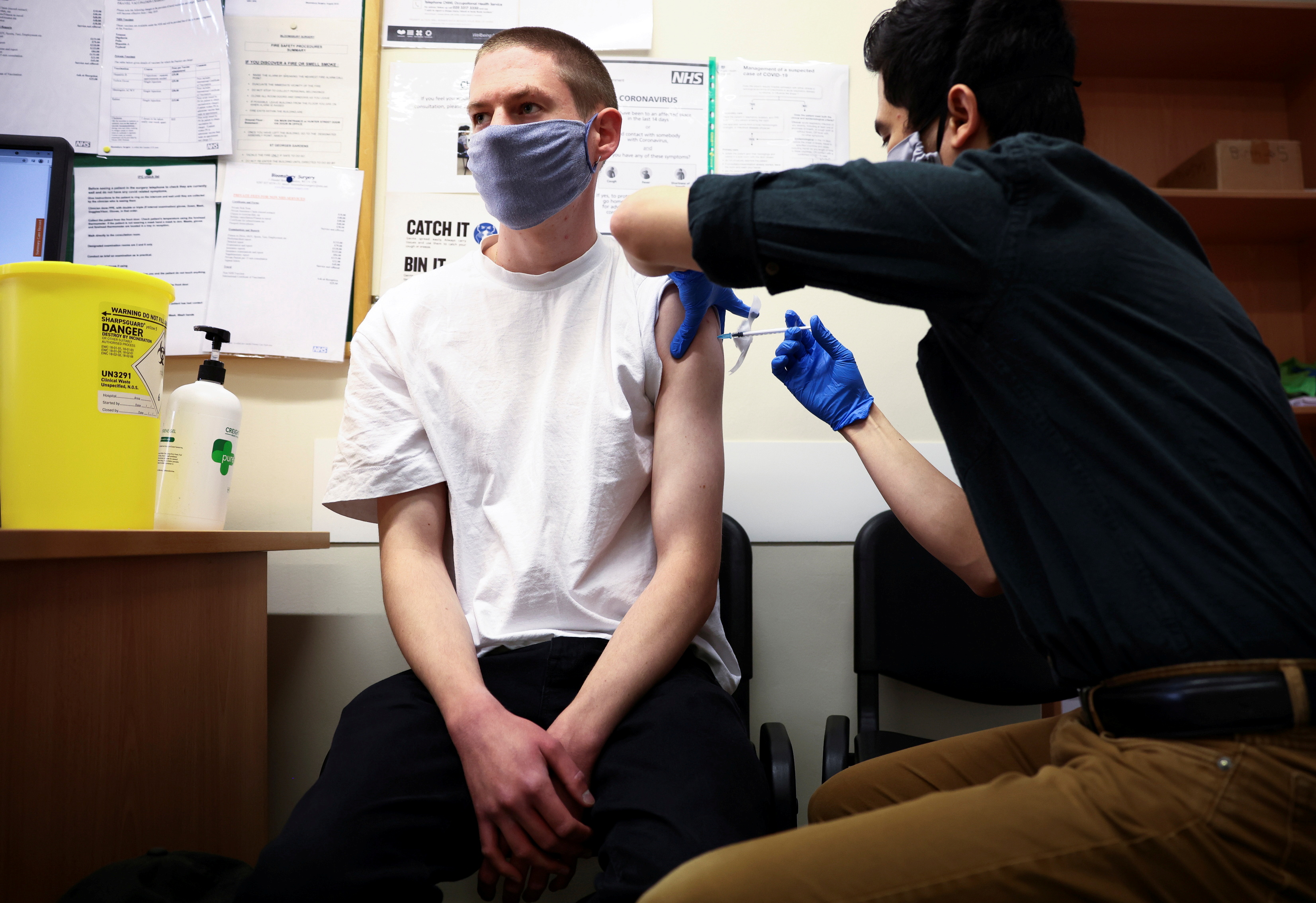 FILE PHOTO: A person receives a dose of the Pfizer BioNTech vaccine, at vaccination centre for young people and students at the Hunter Street Health Centre, amid the coronavirus disease (COVID-19) outbreak, in London