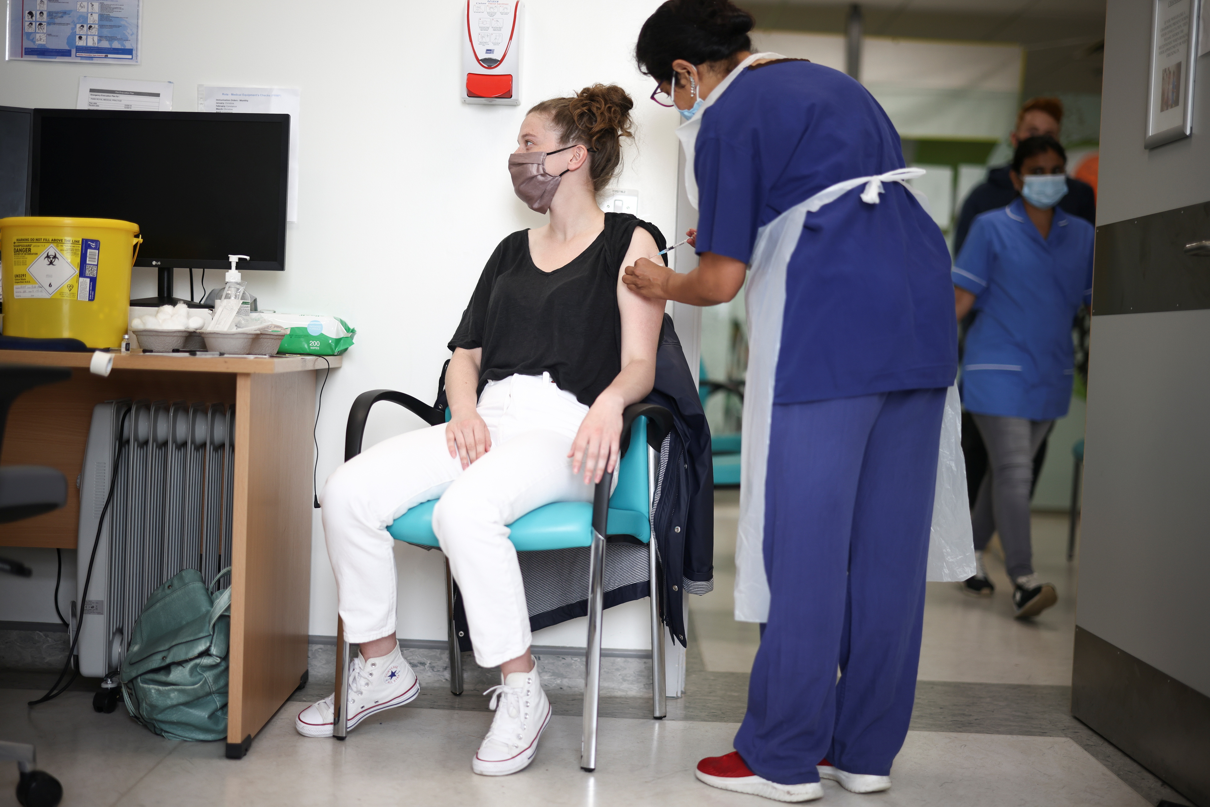A person receives a dose of the Pfizer BioNTech vaccine at the Central Middlesex Hospital in London