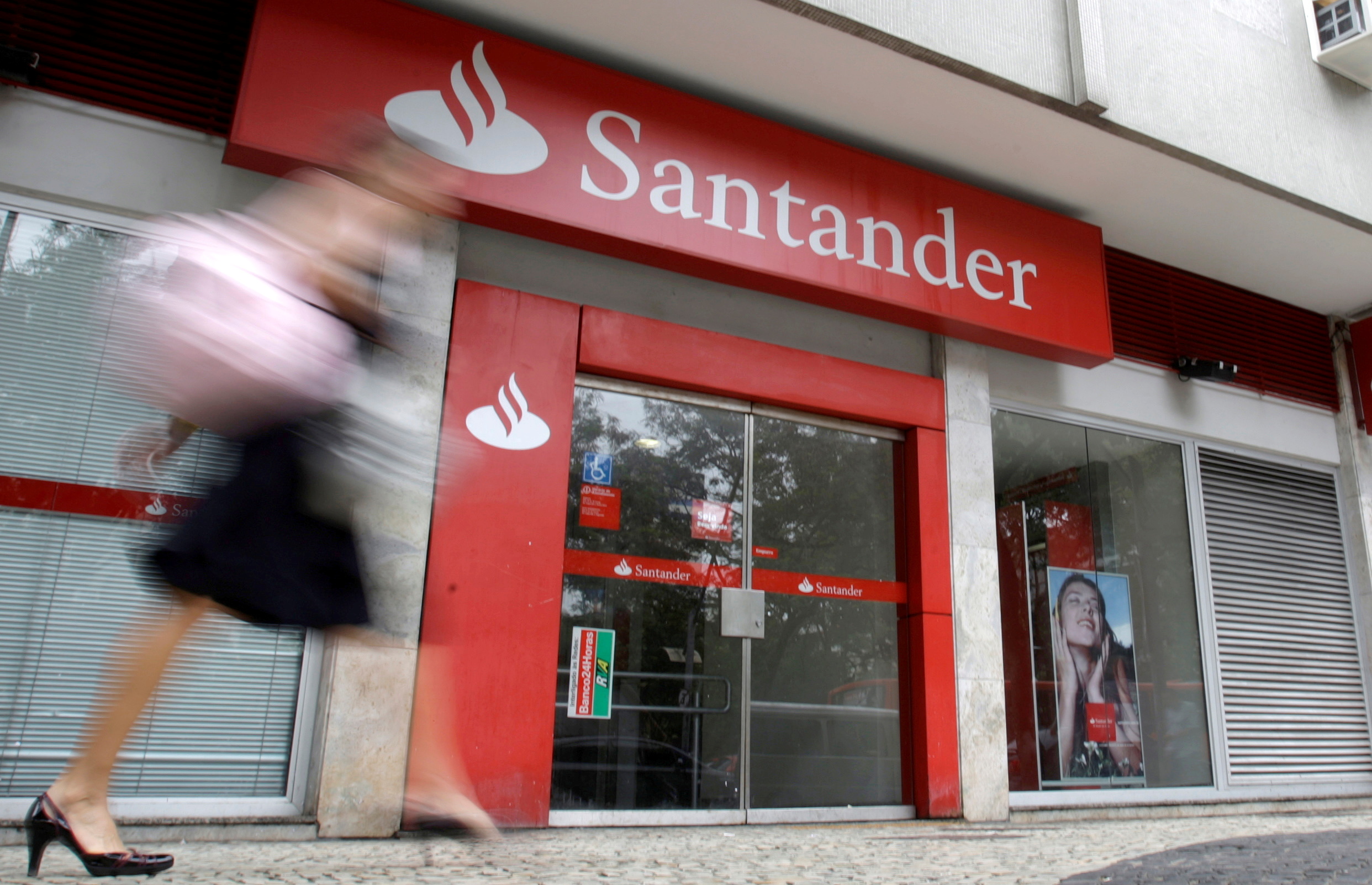 FILE PHOTO: FILE PHOTO: A woman walks past Santander bank branch in Rio de Janeiro