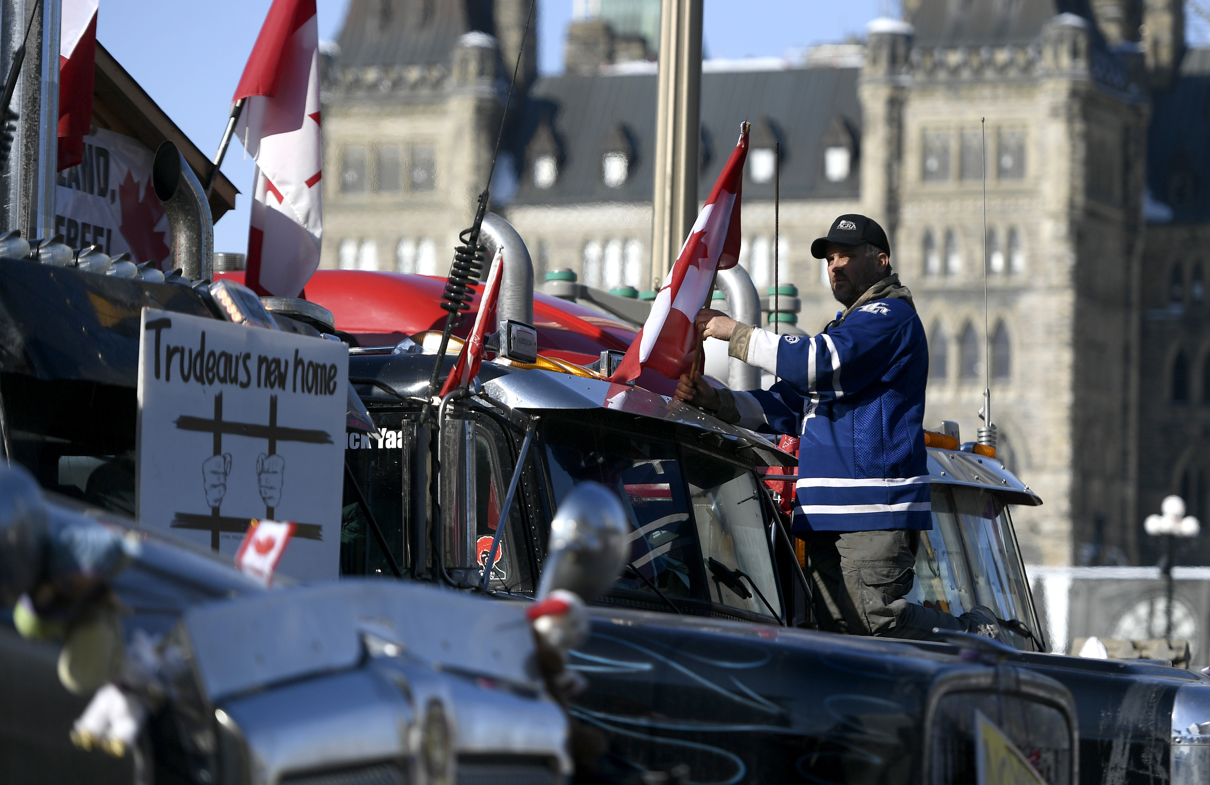 A protester affixes a flag to the top of a truck