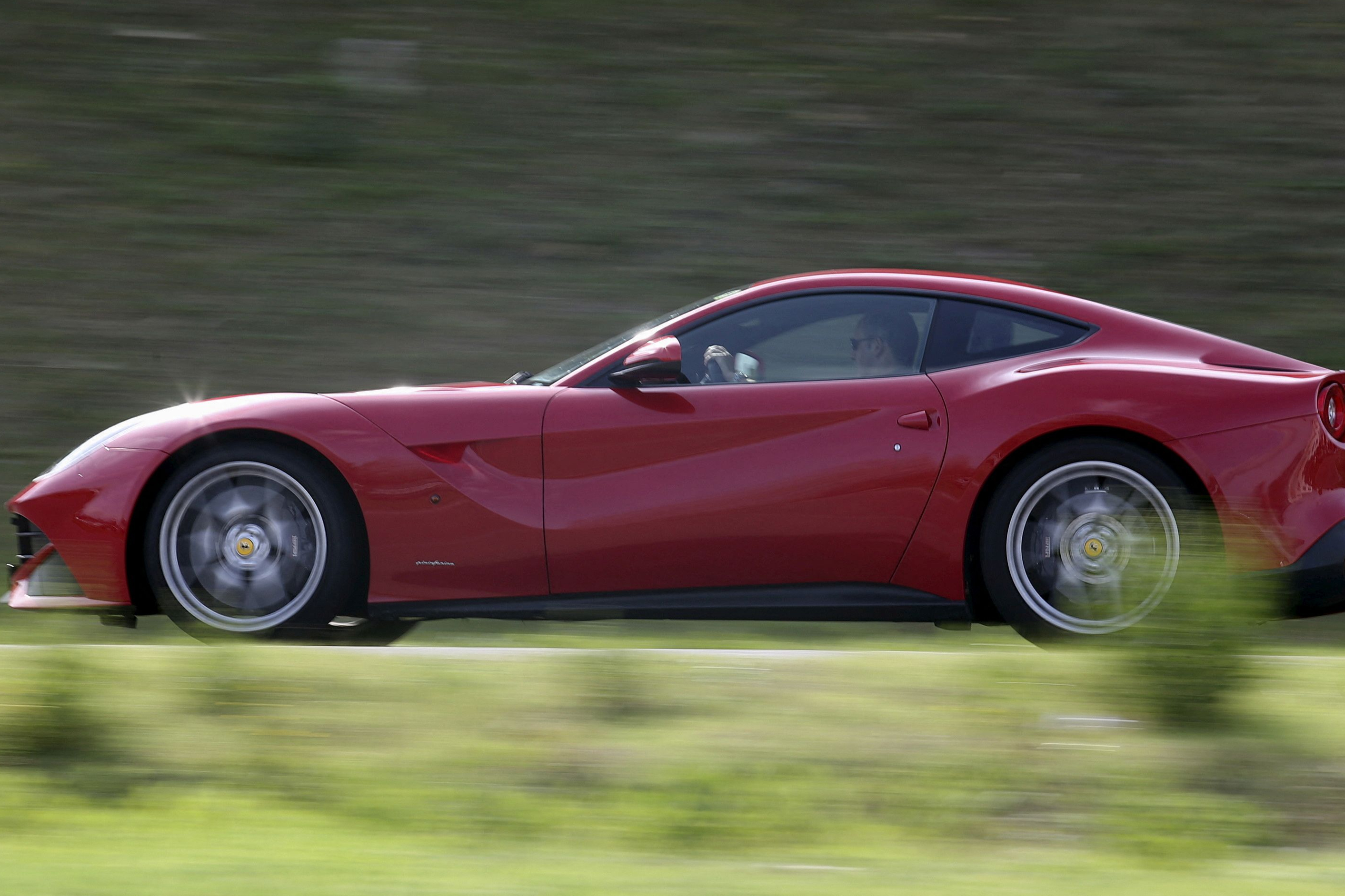 FILE PHOTO: A man drives a Ferrari luxury car in the Ferrari hometown in Maranello