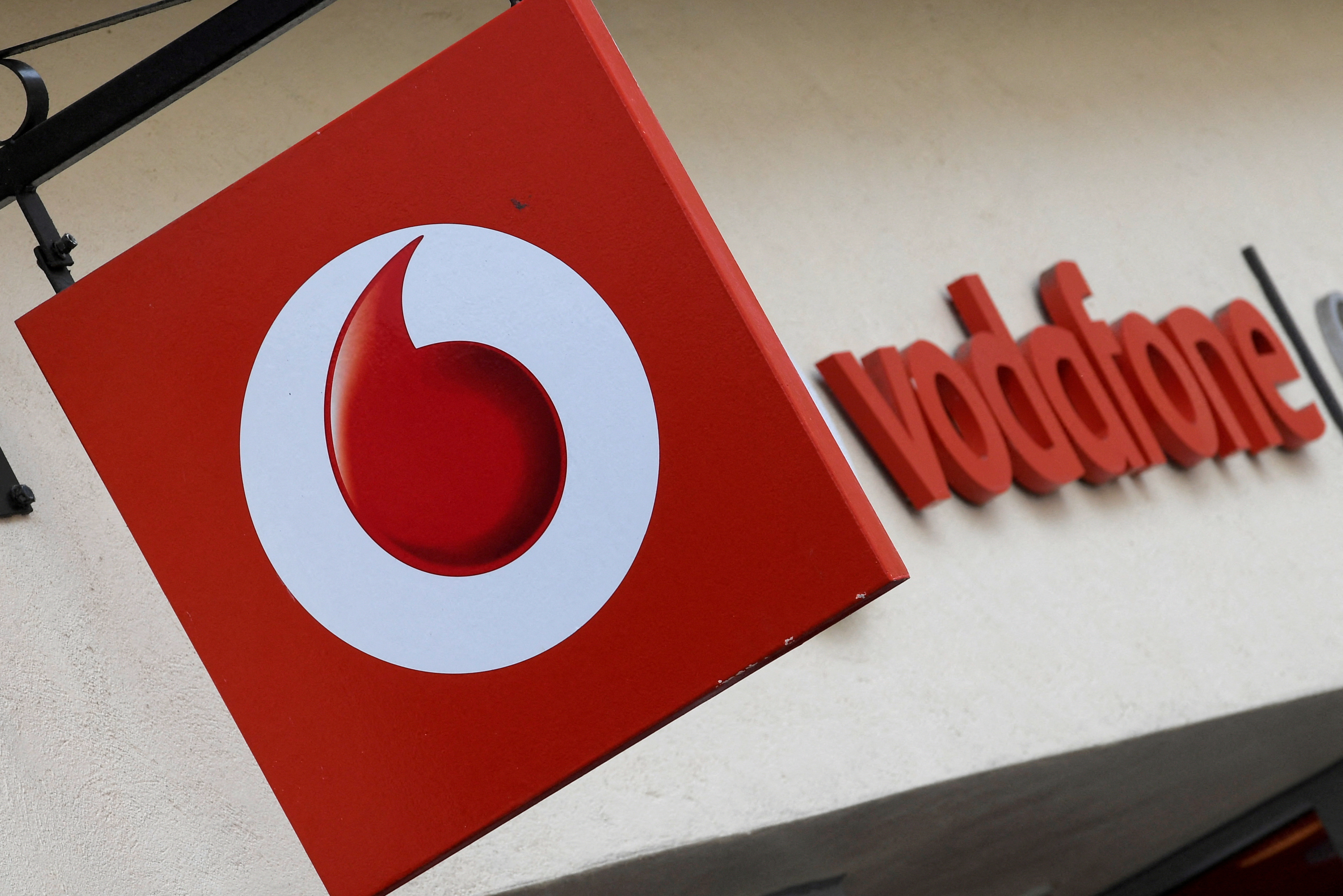 FILE PHOTO: Branding hangs outside a Vodafone shop in Oxford