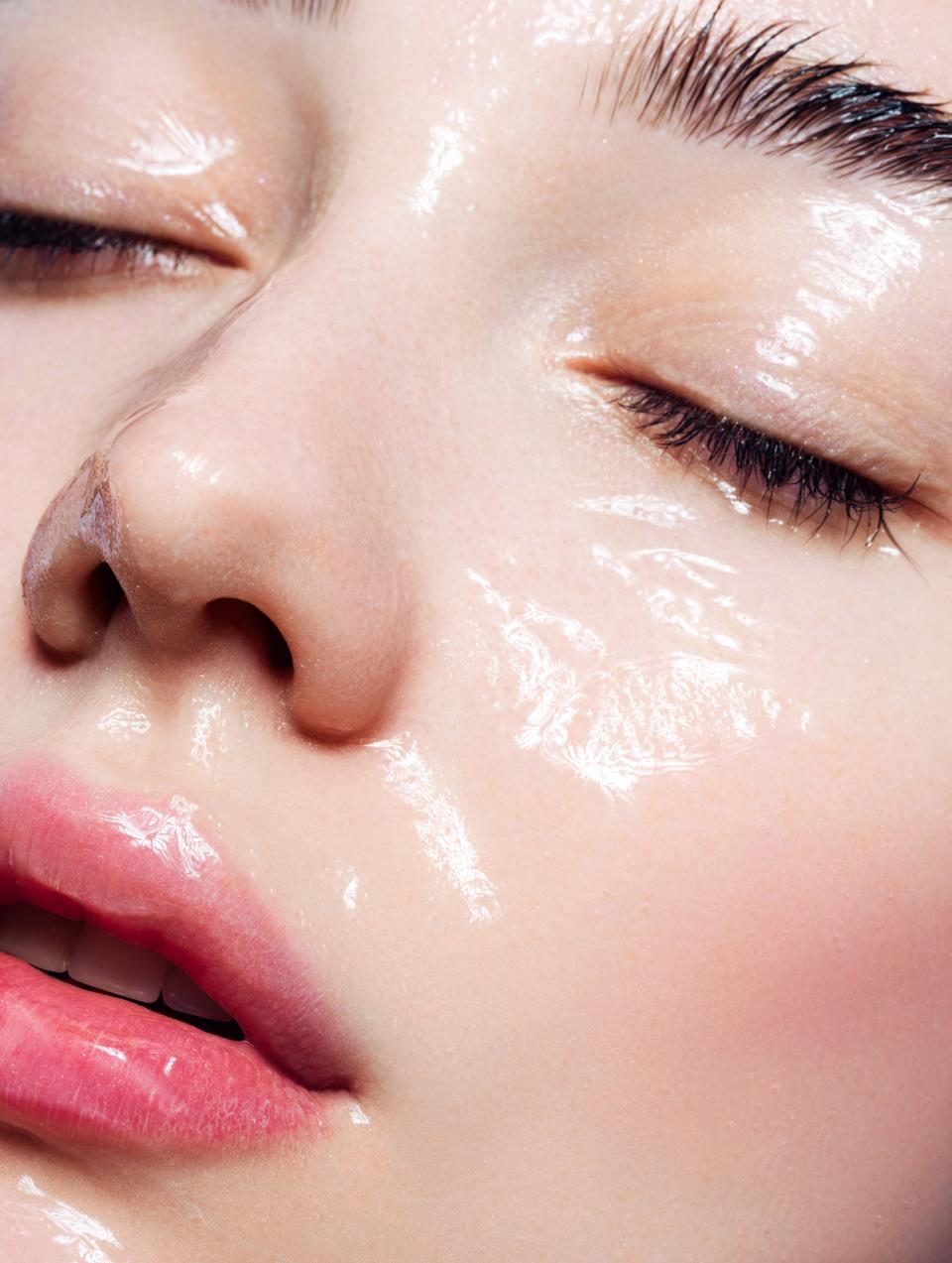 Beautiful young woman with moisturizing gel on her face