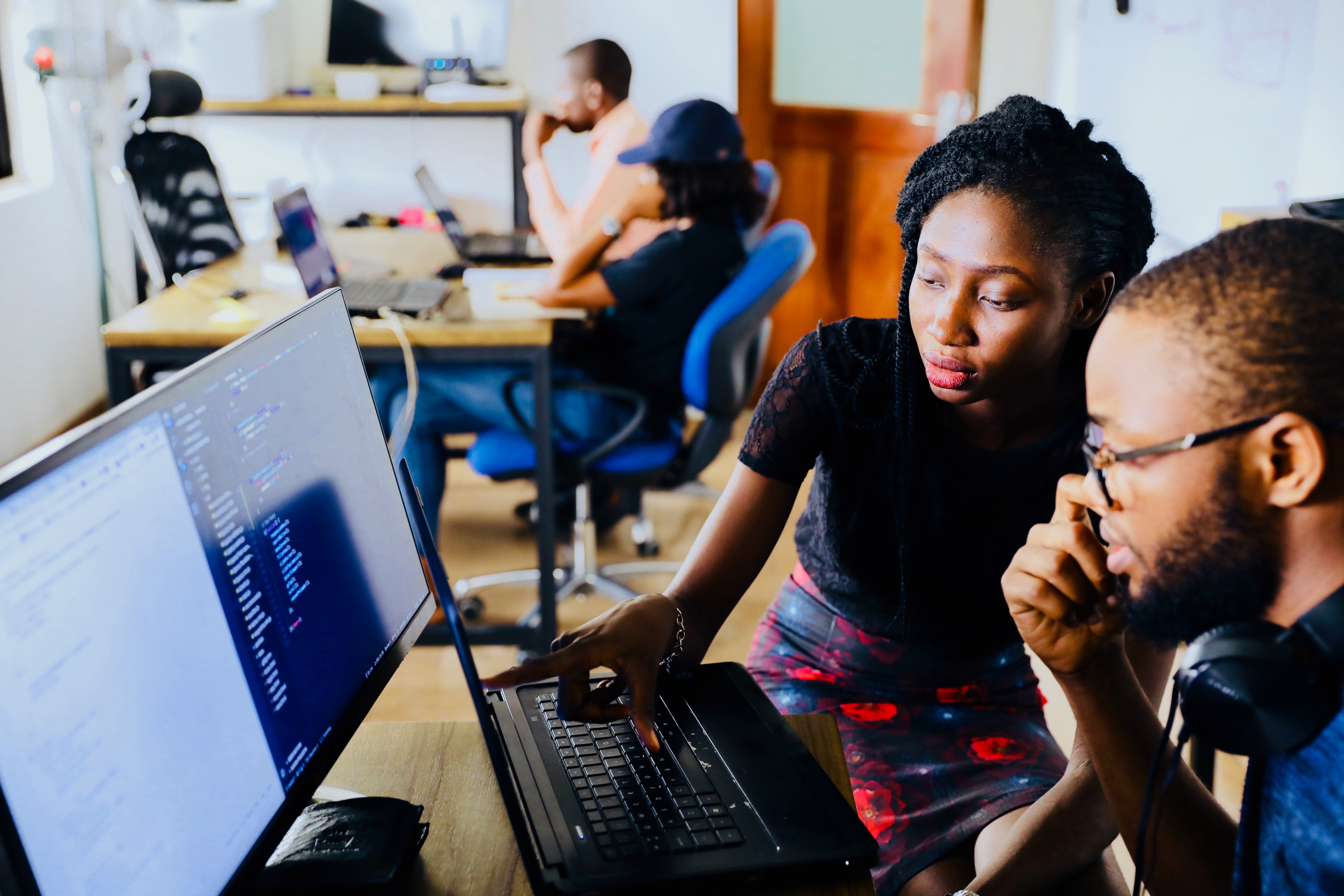 A man and a woman working at a laptop