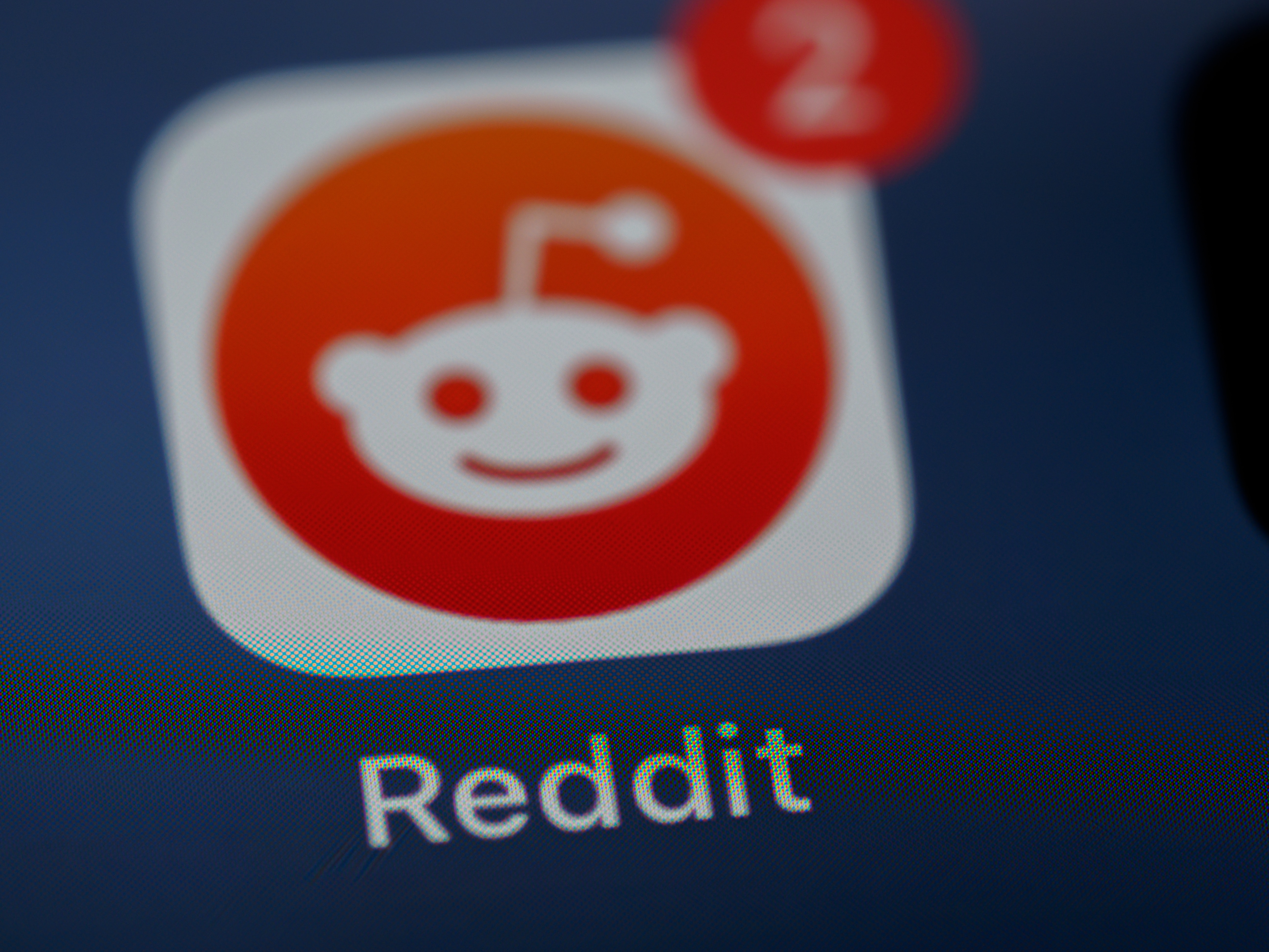 A picture of the Reddit app logo on a smartphone