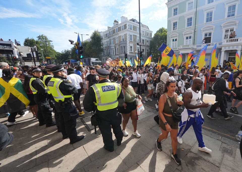 <p>Police officers watch over crowds of people attending the Notting Hill Carnival celebration in west London over the Summer Bank Holiday weekend. Picture date: Monday August 25, 2025. PA Photo. Photo credit should read: Yui Mok/PA Wire</p>