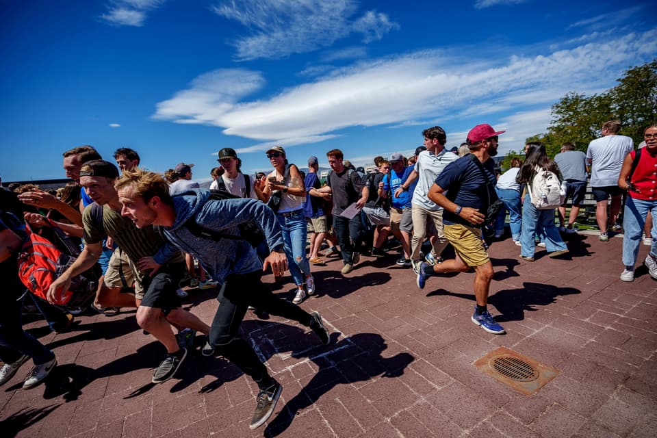 People run after a shot was fired at U.S. right-wing activist and commentator Charlie Kirk at a Utah Valley University speaking event in Orem