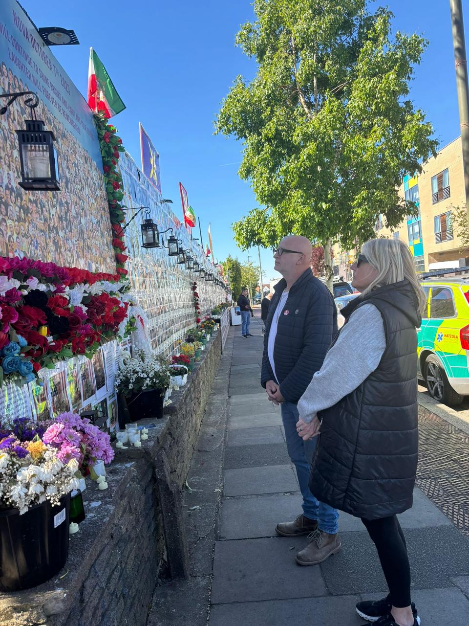 <p>Michael and Lisa Marlow pictured at the memorial wall in Golders Green</p>
