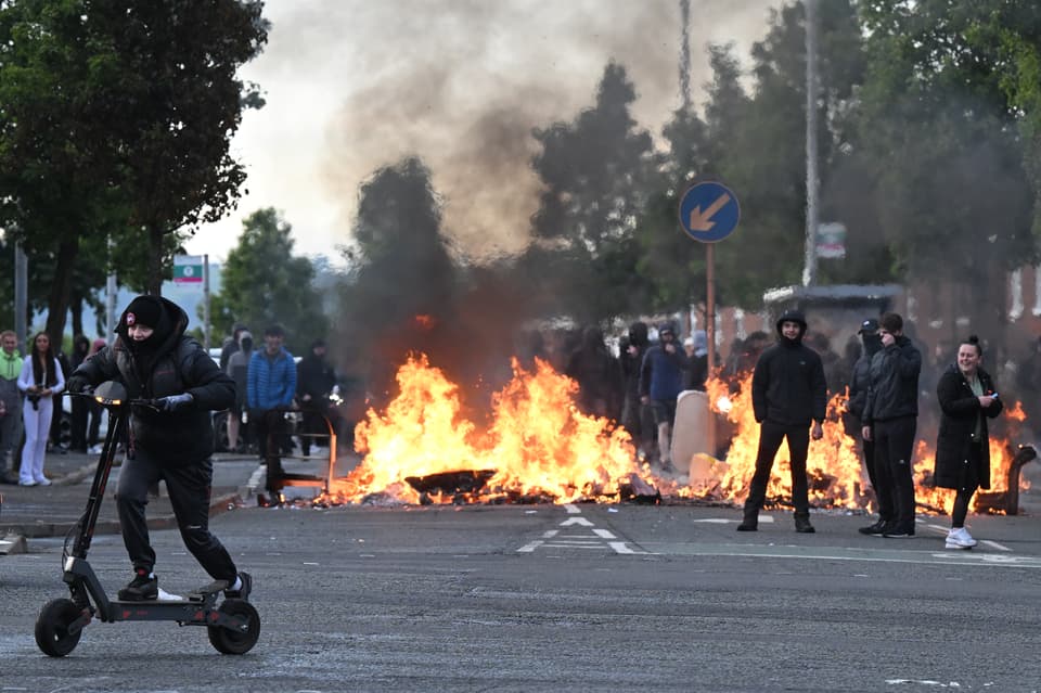 Youths gather in front of a burning barricade on Duncairn Gardens  