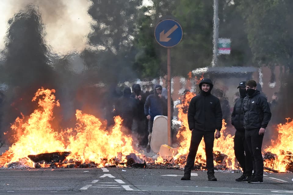Youths gather in front of a burning barricade on Duncairn Gardens  