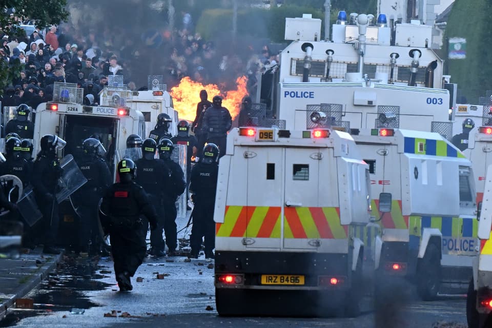 <p>MALLUSK, NORTHERN IRELAND - JUNE 10:  Police stand guard as protests take place near the Chimney Corner Hotel, which allegedly may be a hotel housing migrants, following a night of anti-immigrant riots on June 10, 2026 in Mallusk, Glengormley, Northern Ireland. Overnight protests in Belfast turned violent in reaction to a knife attack that took place on Monday night, which left a male victim in his 40's with serious injuries. Homes and vehicles were torched following the Home Office's confirmation that the suspected knifeman is a 30-year-old asylum seeker from Sudan, who was in the UK on leave to remain. Far-right influencers have been accused of stoking the violence by calling for anti-immigrant demonstrations after a graphic video of the stabbing attack went viral on social media. (Photo by Charles McQuillan/Getty Images)</p>