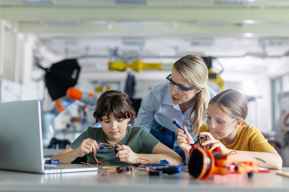 Two primary schoolchildren in a classroom with a teacher