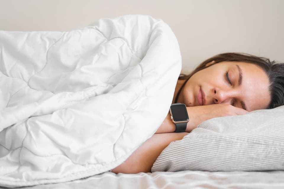 This is a generic photo of a young woman sleeping peacefully in bed while wearing a smartwatch. See PA Feature WELLBEING Sleep. WARNING: This picture must only be used to accompany PA feature WELLBEING Sleep
