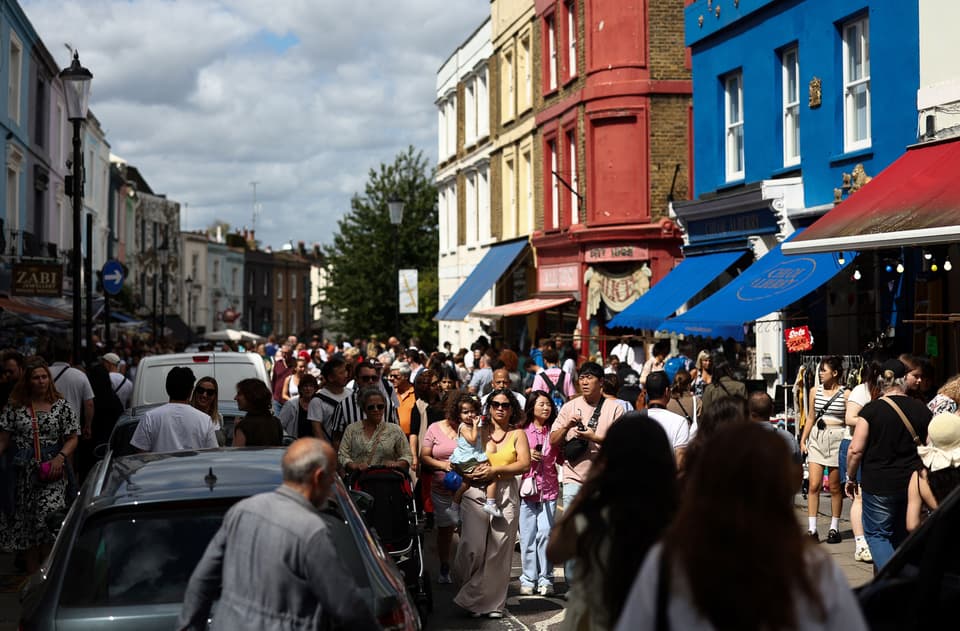 People walk past stalls at Portobello Road Market in west London on August 19, 2023. (Photo by HENRY NICHOLLS / AFP) (Photo by HENRY NICHOLLS/AFP via Getty Images)