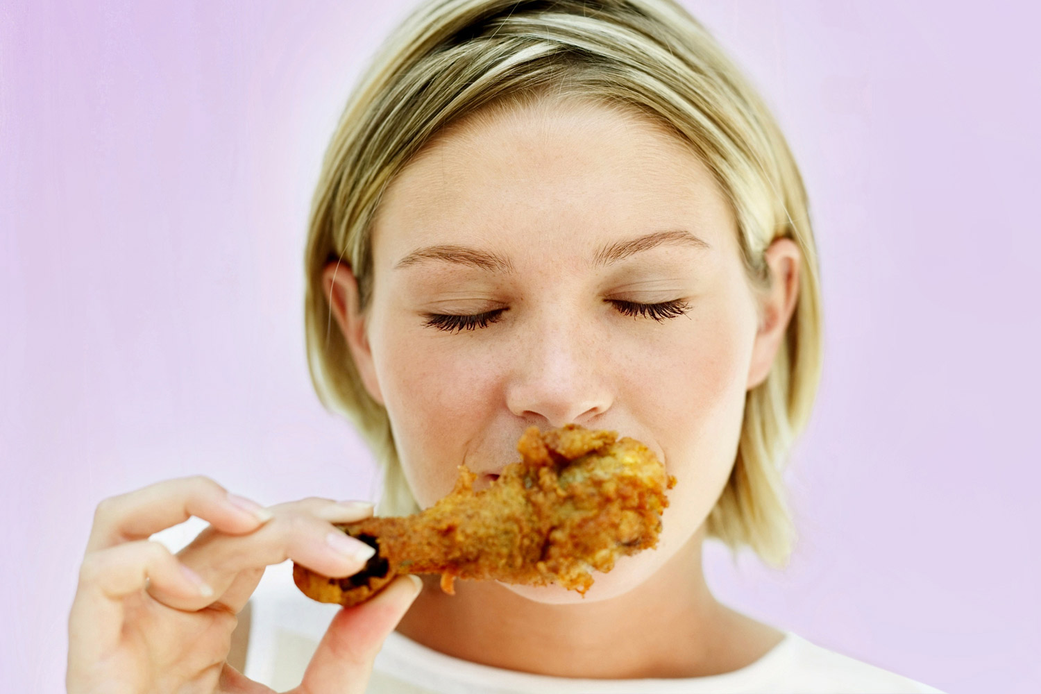 woman eating a fried chicken drumstick