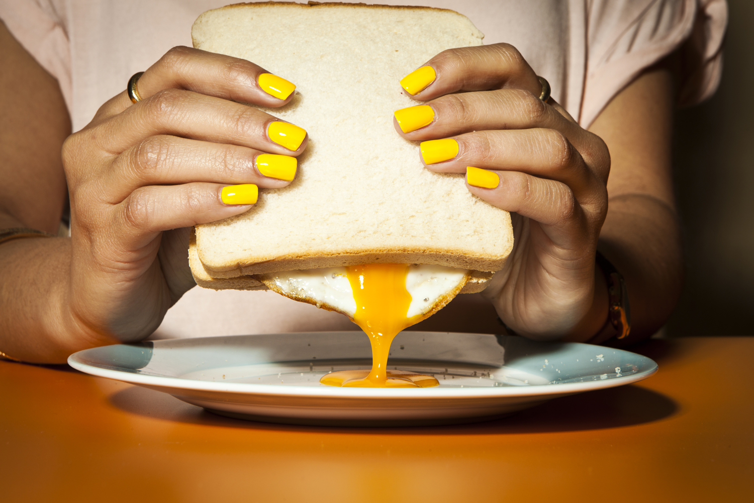 hands yellow nails egg sandwhich 